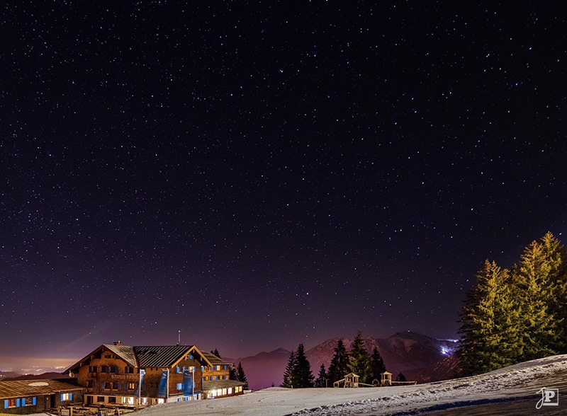 Mountain inn under a sky full of stars